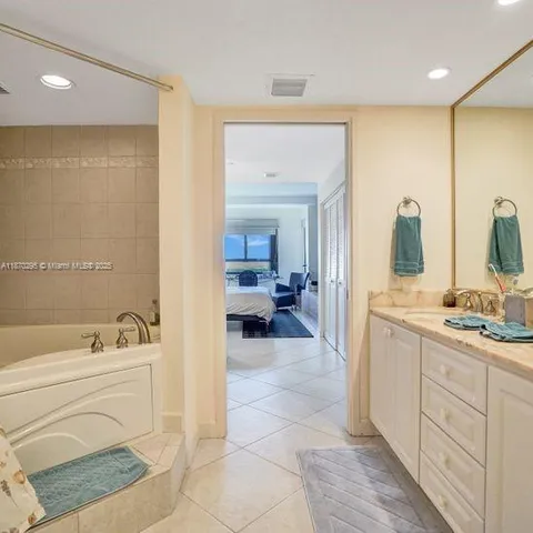 a bathroom with a tub sink and mirror