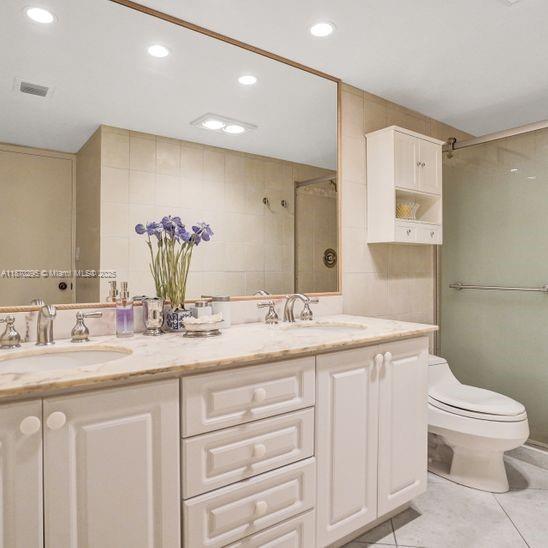 151 Crandon Boulevard, Unit 1130 Key Biscayne, FL 33149 - Photo 17 of 30 a bathroom with a granite countertop sink a toilet and a mirror