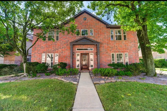 a front view of a house with yard and green space