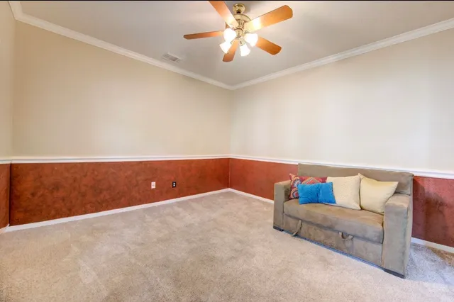 a living room with a couch and a ceiling fan