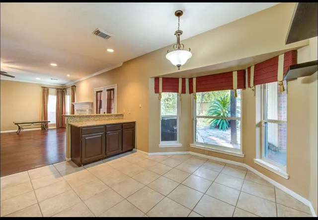 a open kitchen with kitchen island granite countertop a refrigerator a sink a stove and island with wooden floor