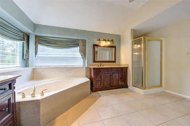 a spacious bathroom with a tub sink and mirror