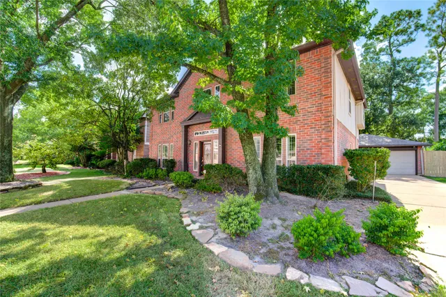 a view of a house with a yard and basketball court
