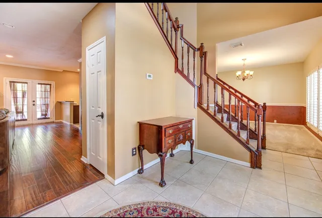 a view of a hallway with wooden floor and staircase
