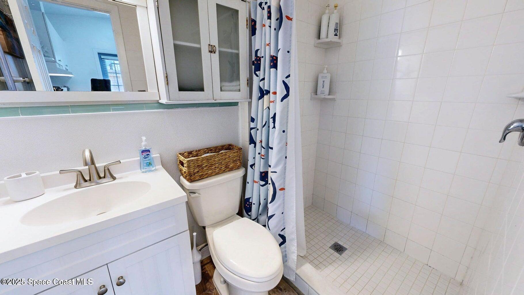701 South Orlando Avenue, Unit C Cocoa Beach, FL 32931 - Photo 10 of 12 a bathroom with a sink toilet and shower