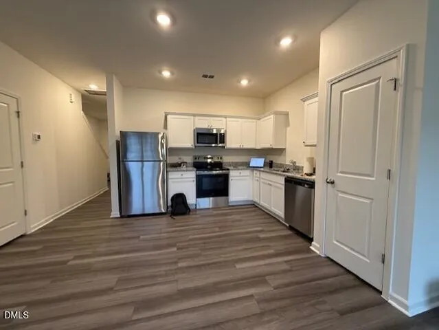 a view of kitchen with refrigerator microwave and stove