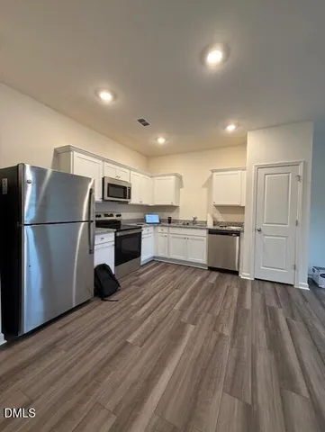 a kitchen with wooden floors and appliances