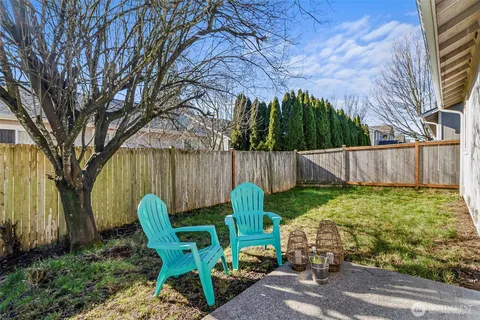 a backyard of a house with table and chairs