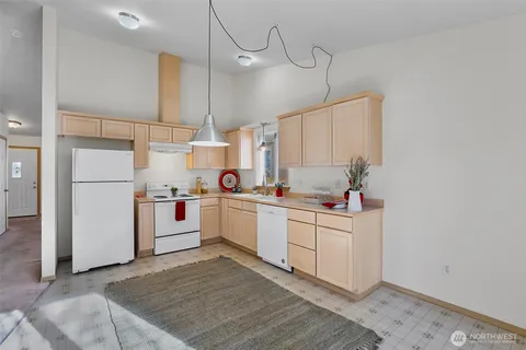 a kitchen with white cabinets and white appliances