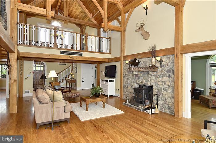 18340 Cattail Road Poolesville, MD 20837 - Photo 24 of 30 a living room with furniture a fireplace and a floor to ceiling window