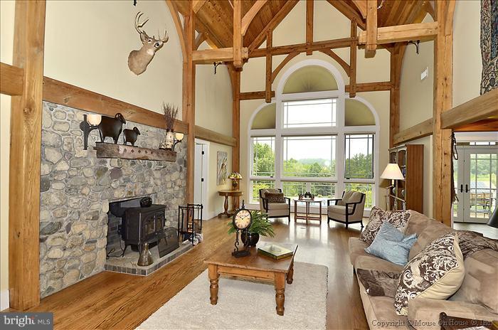 18340 Cattail Road Poolesville, MD 20837 - Photo 4 of 30 a living room with furniture a fireplace and floor to ceiling windows