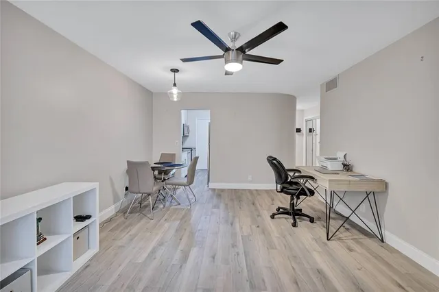 a workspace room with wooden floor table and chairs
