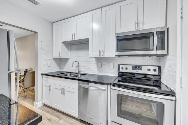 a kitchen with a sink a refrigerator and cabinets