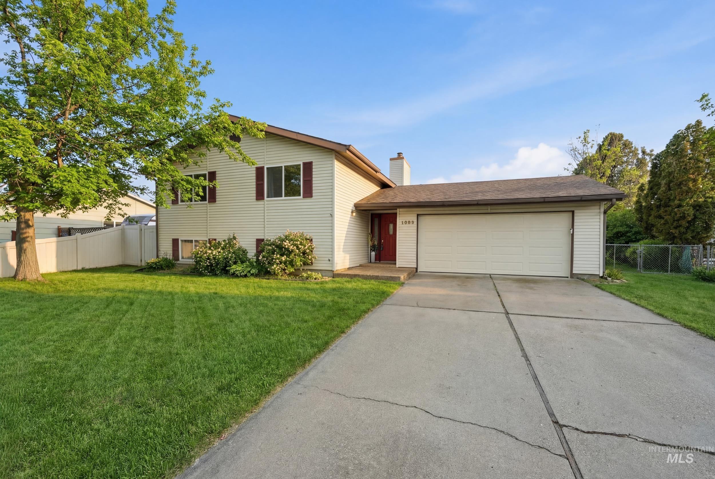 3589 South Minuteman Way Boise, ID 83706 - Photo 1 of 1 Split level home featuring a garage, driveway, and a chimney