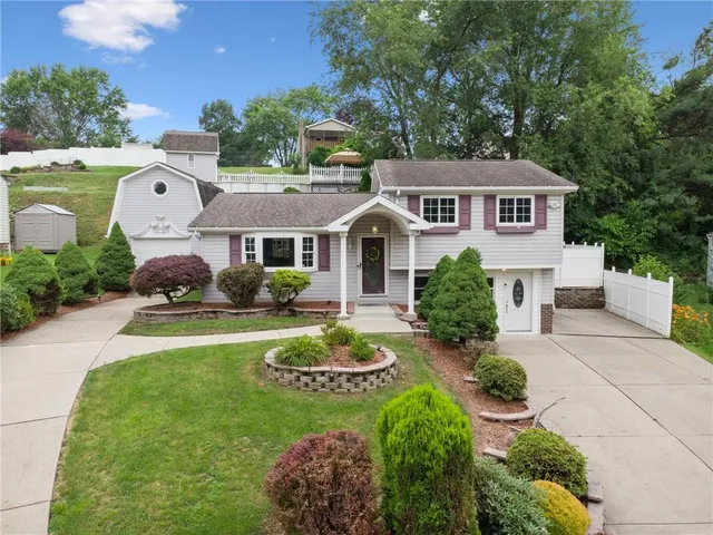 a front view of a house with a garden and plants