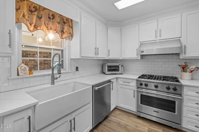 a kitchen with white cabinets and white appliances