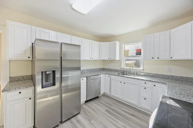 a view of empty room with wooden floor and windows
