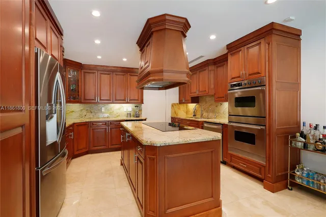 a kitchen with stainless steel appliances granite countertop a refrigerator a stove and a sink