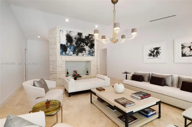 a living room with furniture a rug and wall paintings