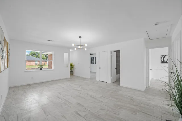 an empty room with windows and ceiling fan