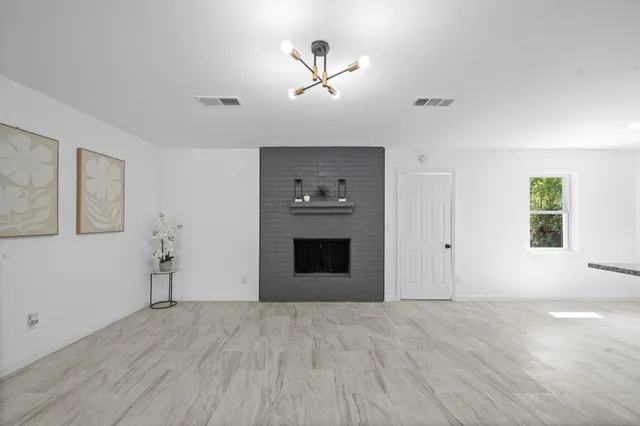 a view of empty room with a fireplace and wooden floor