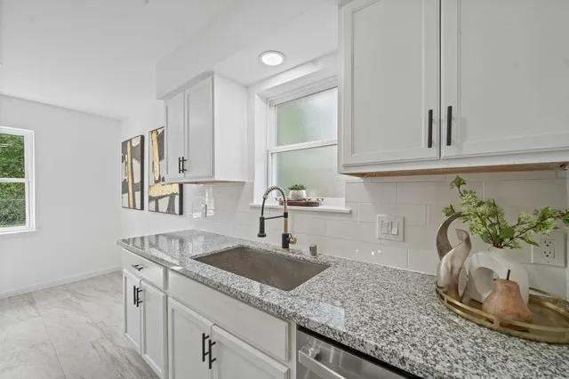 a kitchen with granite countertop a sink and a white stove