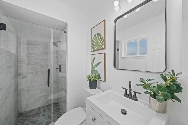 a bathroom with a sink a toilet and a mirror