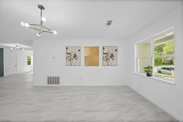 a view of empty room with window and ceiling fan