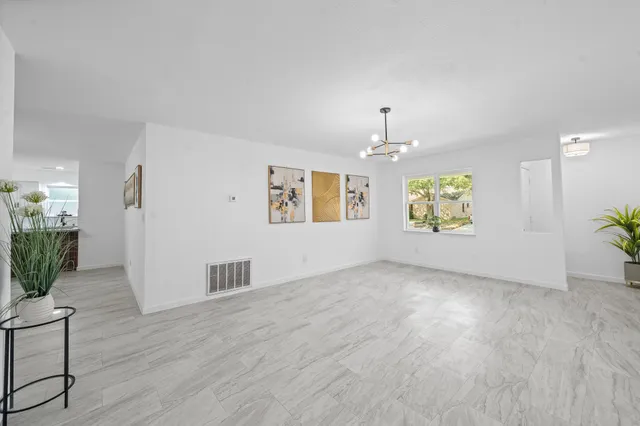 an empty room with windows and cabinet