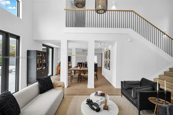 a living room with furniture a wooden floor and a potted plant