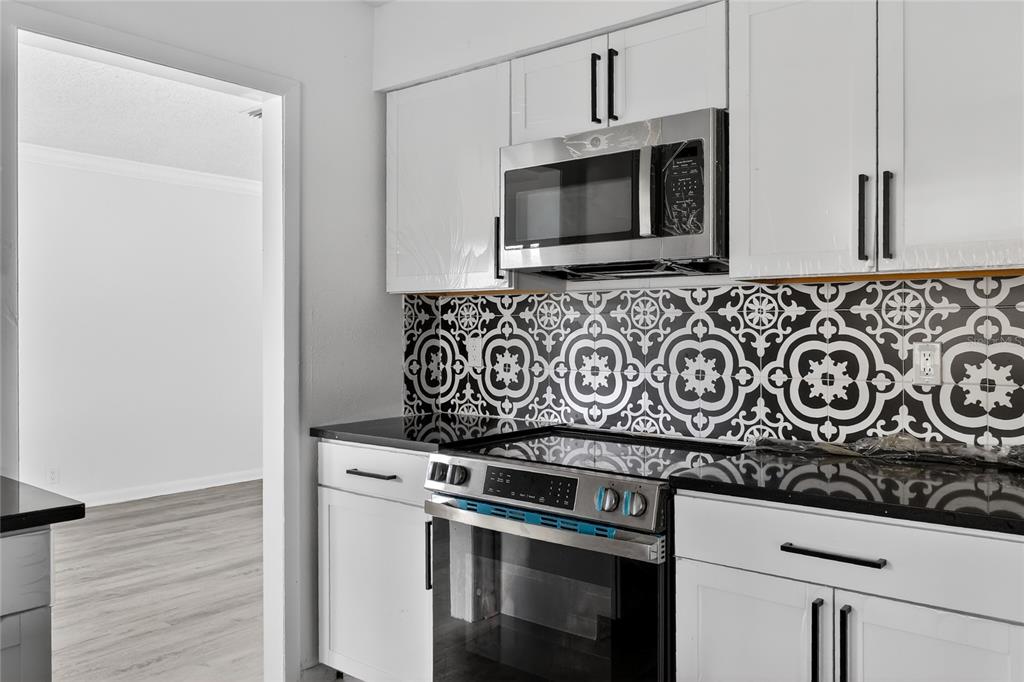 148 Lake Otis Road Winter Haven, FL 33884 - Photo 13 of 44 a view of a kitchen with stove and microwave