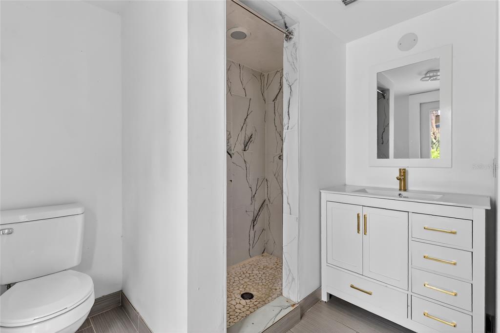 148 Lake Otis Road Winter Haven, FL 33884 - Photo 19 of 44 a bathroom with a granite countertop sink a toilet and a mirror