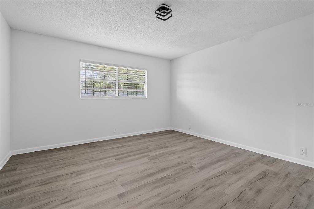 148 Lake Otis Road Winter Haven, FL 33884 - Photo 24 of 44 an empty room with wooden floor and windows
