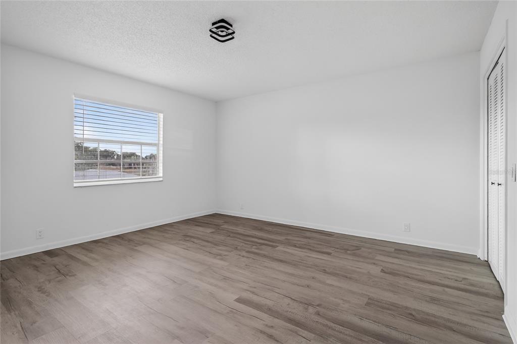 148 Lake Otis Road Winter Haven, FL 33884 - Photo 27 of 44 a view of an empty room with wooden floor and a window