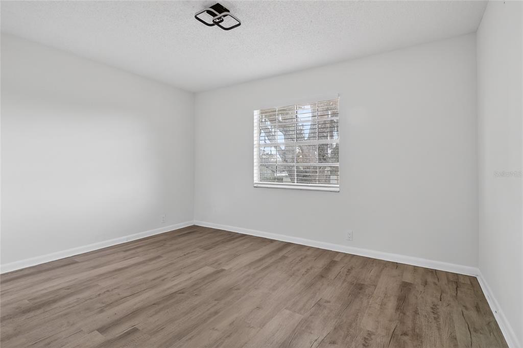 148 Lake Otis Road Winter Haven, FL 33884 - Photo 28 of 44 an empty room with wooden floor and windows