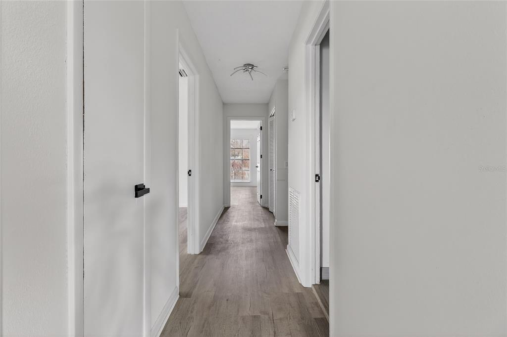 148 Lake Otis Road Winter Haven, FL 33884 - Photo 30 of 44 a view of a hallway with wooden floor and a bathroom