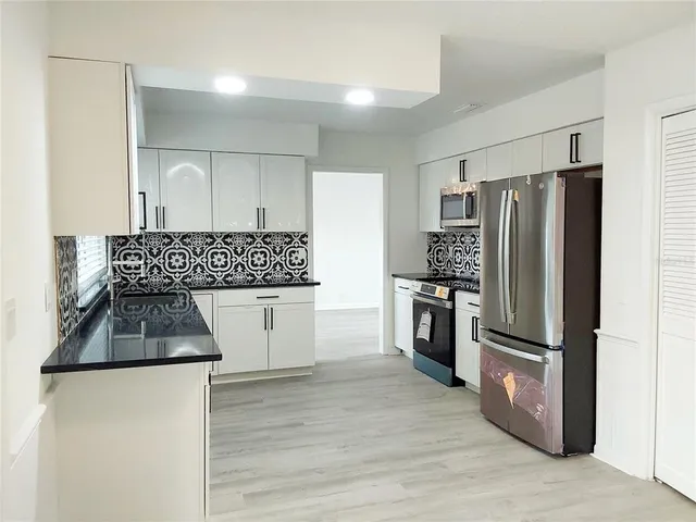a kitchen with a refrigerator and a stove top oven
