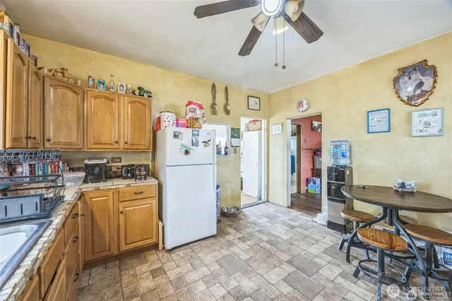 a view of a kitchen with fridge and workspace
