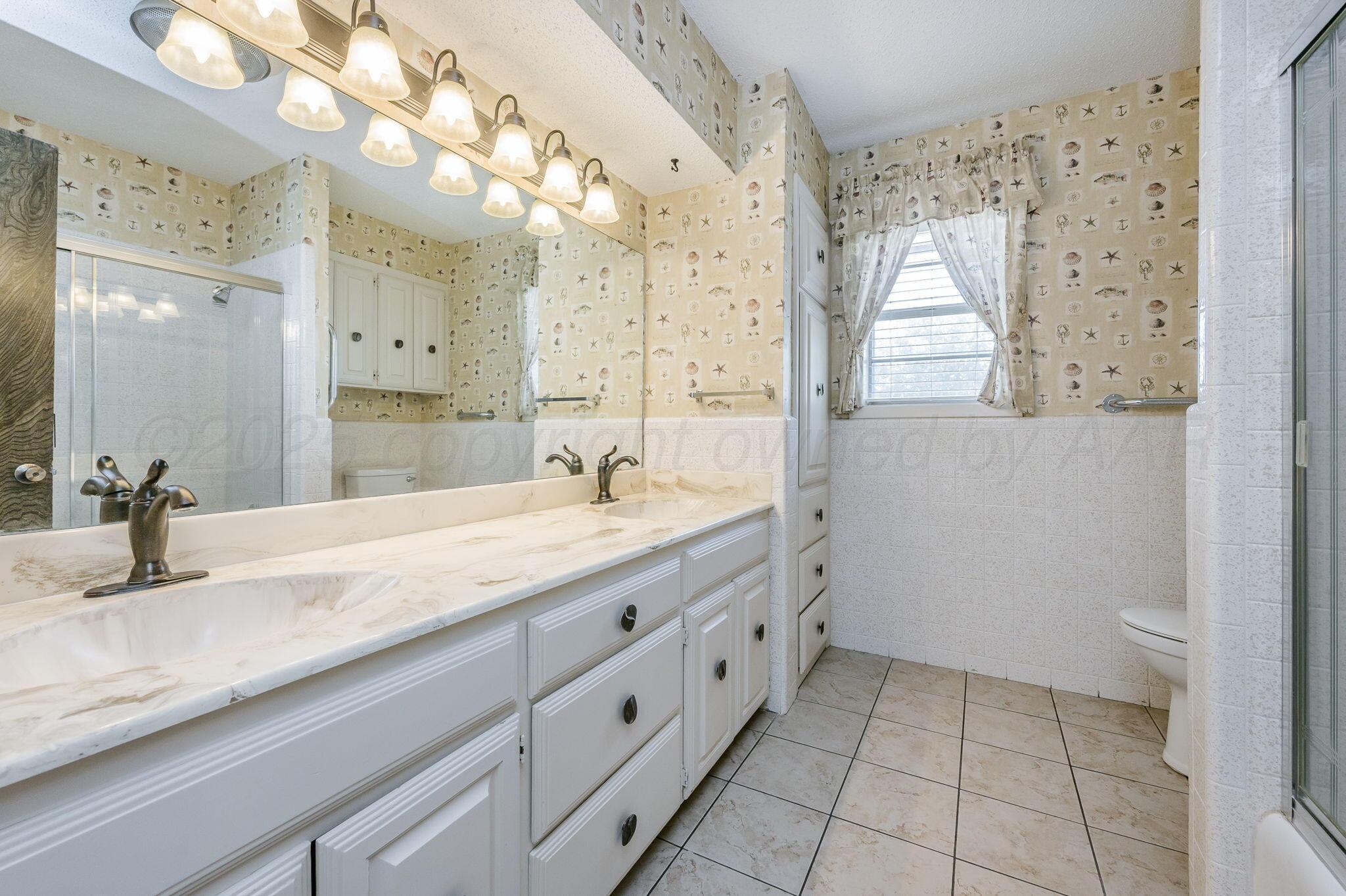 1102 Creekmere Drive Canyon, TX 79015 - Photo 23 of 29 a bathroom with a sink a vanity and a mirror