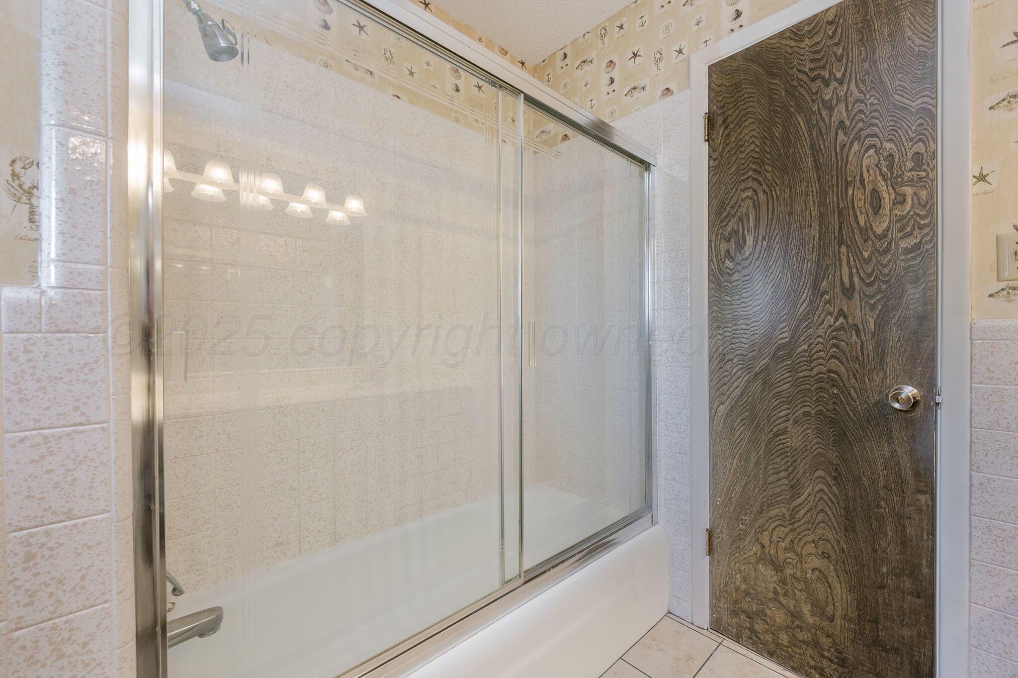 1102 Creekmere Drive Canyon, TX 79015 - Photo 24 of 29 a bathroom with a glass shower door