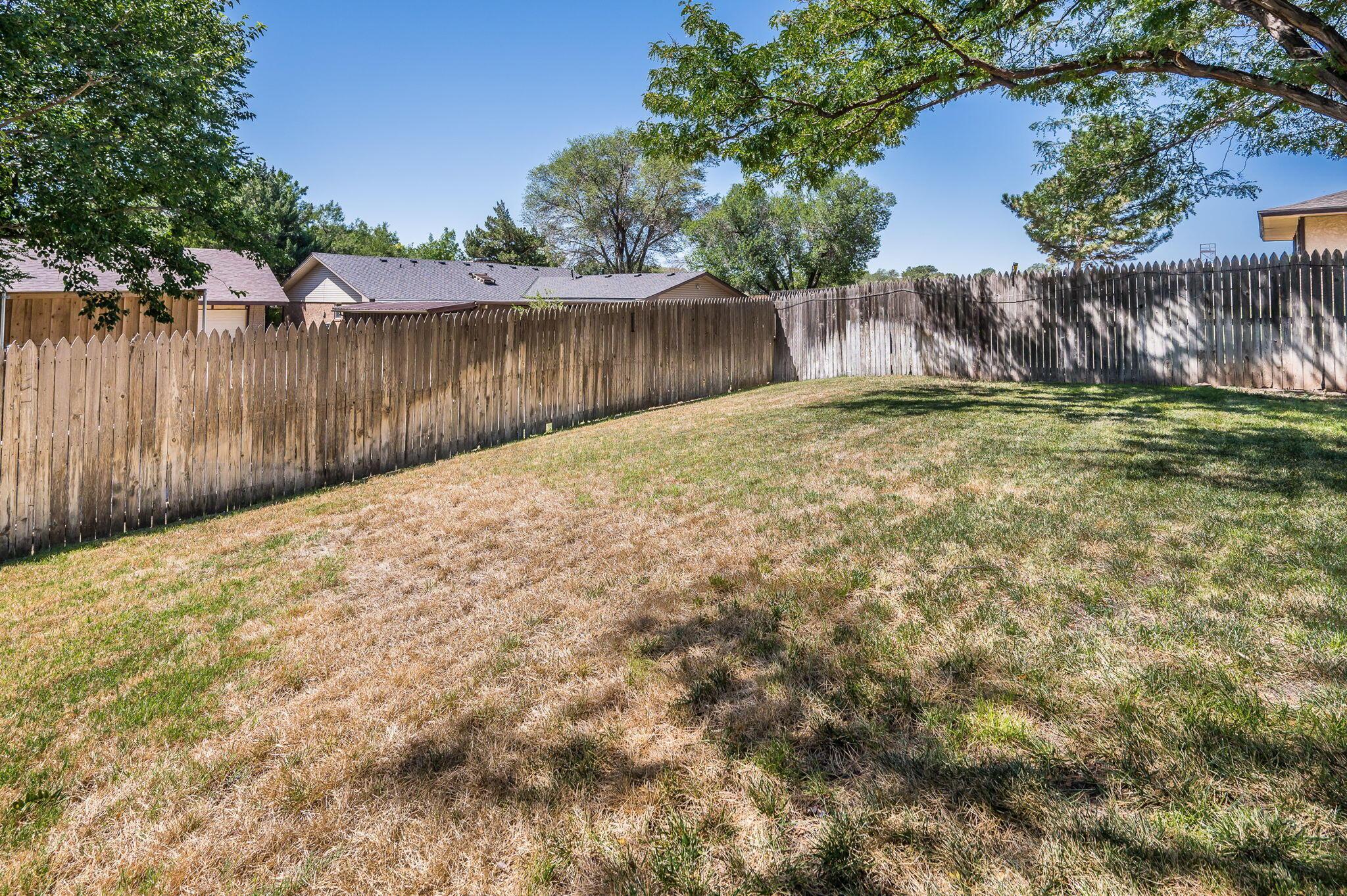 1102 Creekmere Drive Canyon, TX 79015 - Photo 26 of 29 a view of a backyard with large tree and wooden fence
