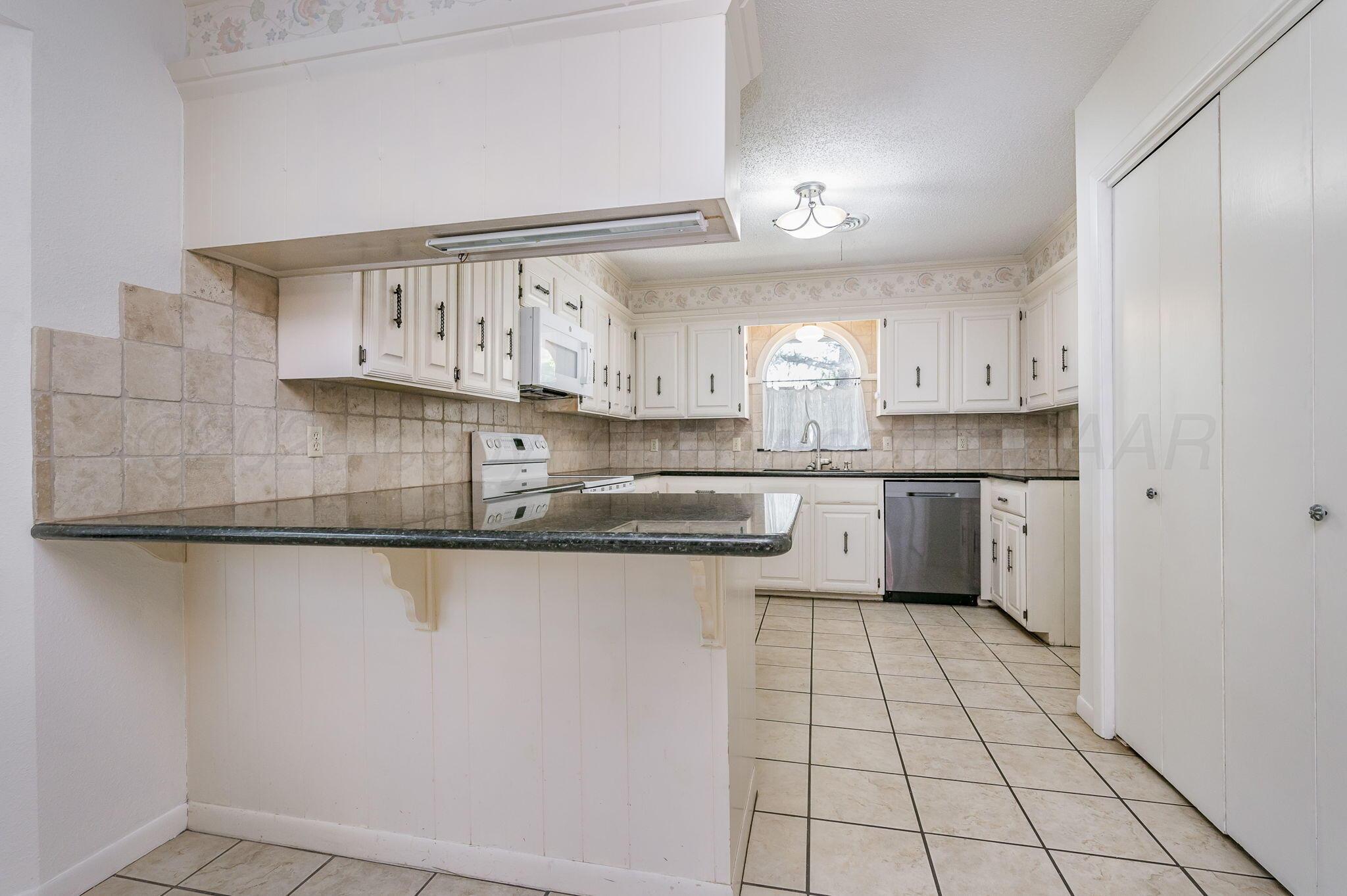 1102 Creekmere Drive Canyon, TX 79015 - Photo 5 of 29 a kitchen with stainless steel appliances a sink stove and cabinets