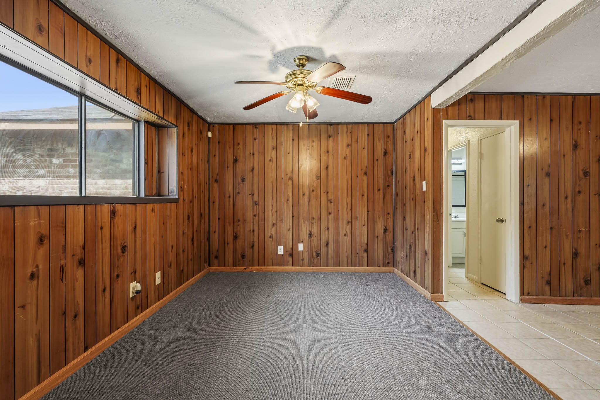 5315 Ridgestone Street Houston, TX 77053 - Photo 4 of 19 Just off the entrance, the den offers a versatile space with warm wood-paneled walls and natural light.