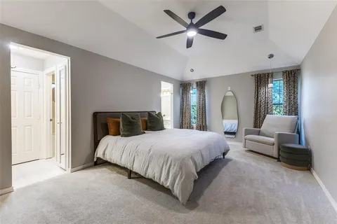 a bedroom with a large bed couch and a window