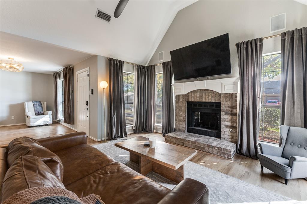 8209 Weatherly Drive Rowlett, TX 75089 - Photo 2 of 25 a living room with furniture a flat screen tv and a fireplace