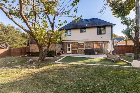 a backyard of a house with table and chairs