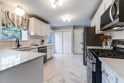 a kitchen with stainless steel appliances a stove a sink and a refrigerator