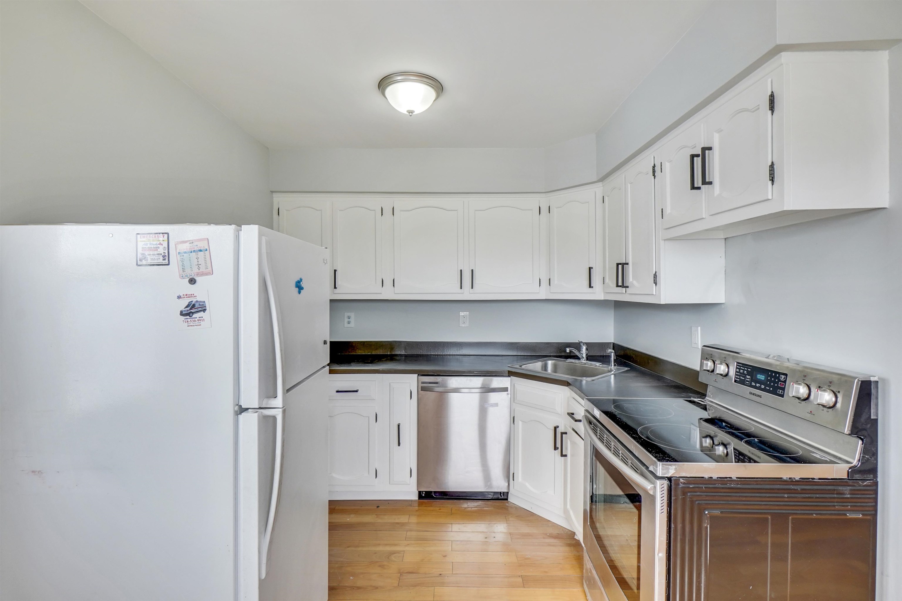 1138F Farm Road, Unit G Secaucus, NJ 07094 - Photo 13 of 26 a kitchen with stainless steel appliances a stove a refrigerator and cabinets