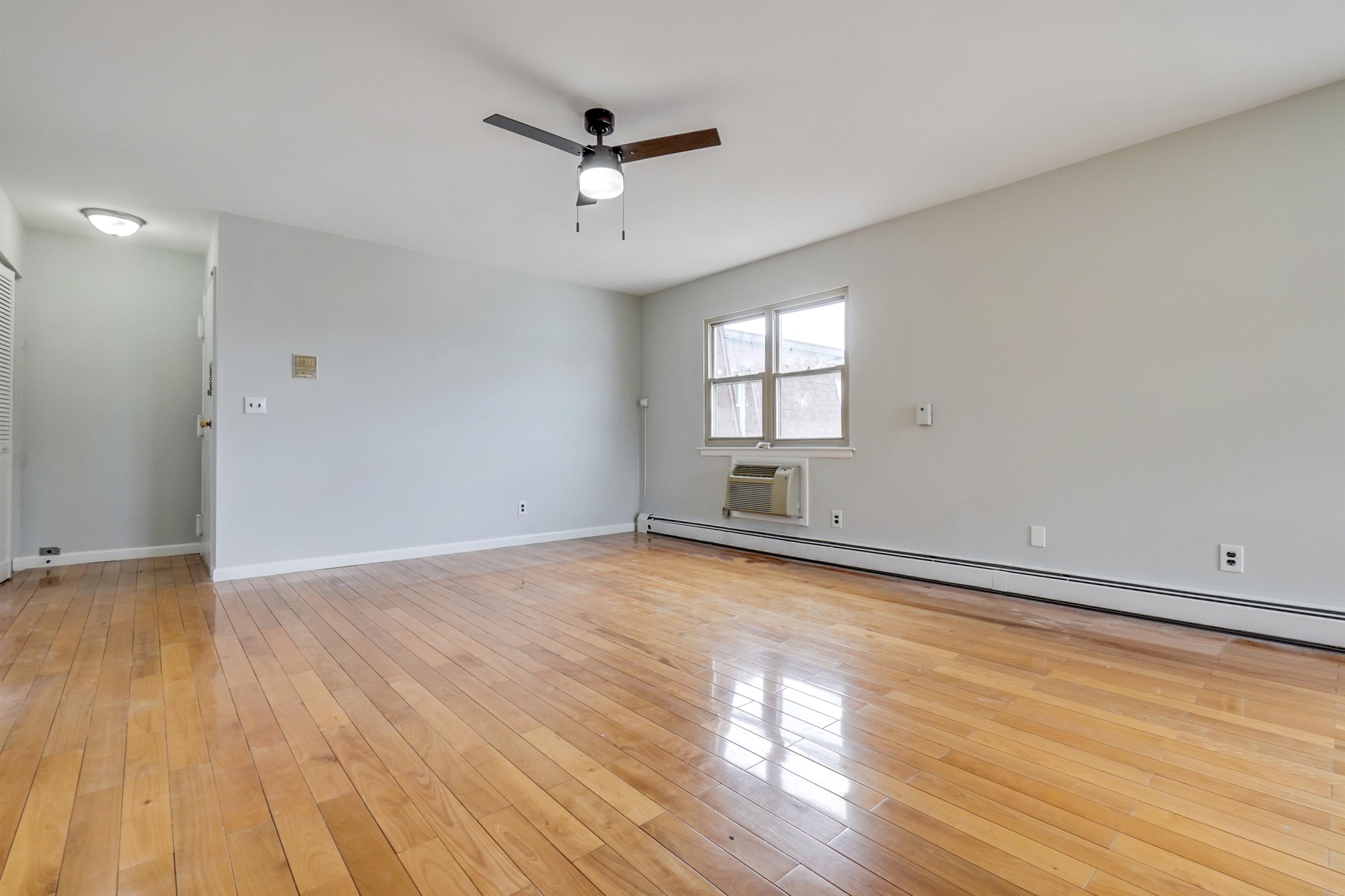 1138F Farm Road, Unit G Secaucus, NJ 07094 - Photo 10 of 26 wooden floor in an empty room with a window