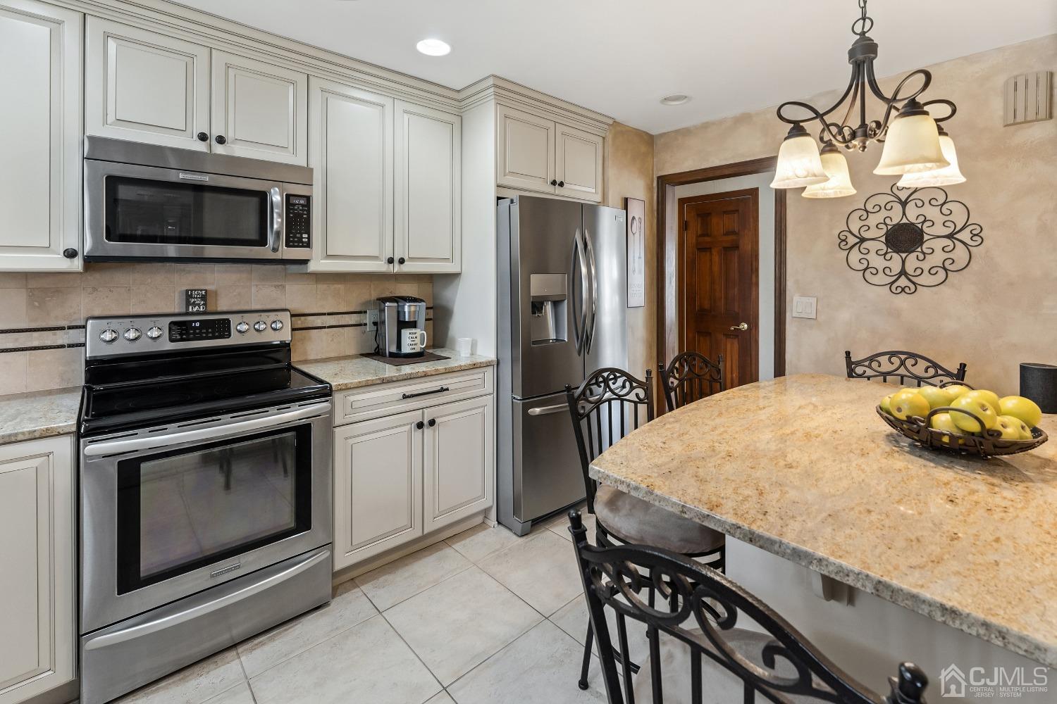 121 Harding Avenue Edison, NJ 08820 - Photo 3 of 30 a kitchen with stainless steel appliances a stove a sink a microwave and cabinets